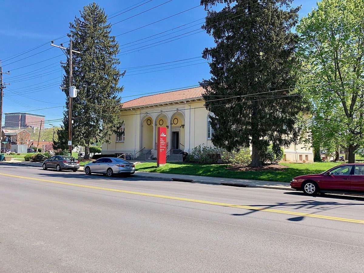A tree-lined street with a small columned library building in the Madisonville neighborhood of Cincinnati
