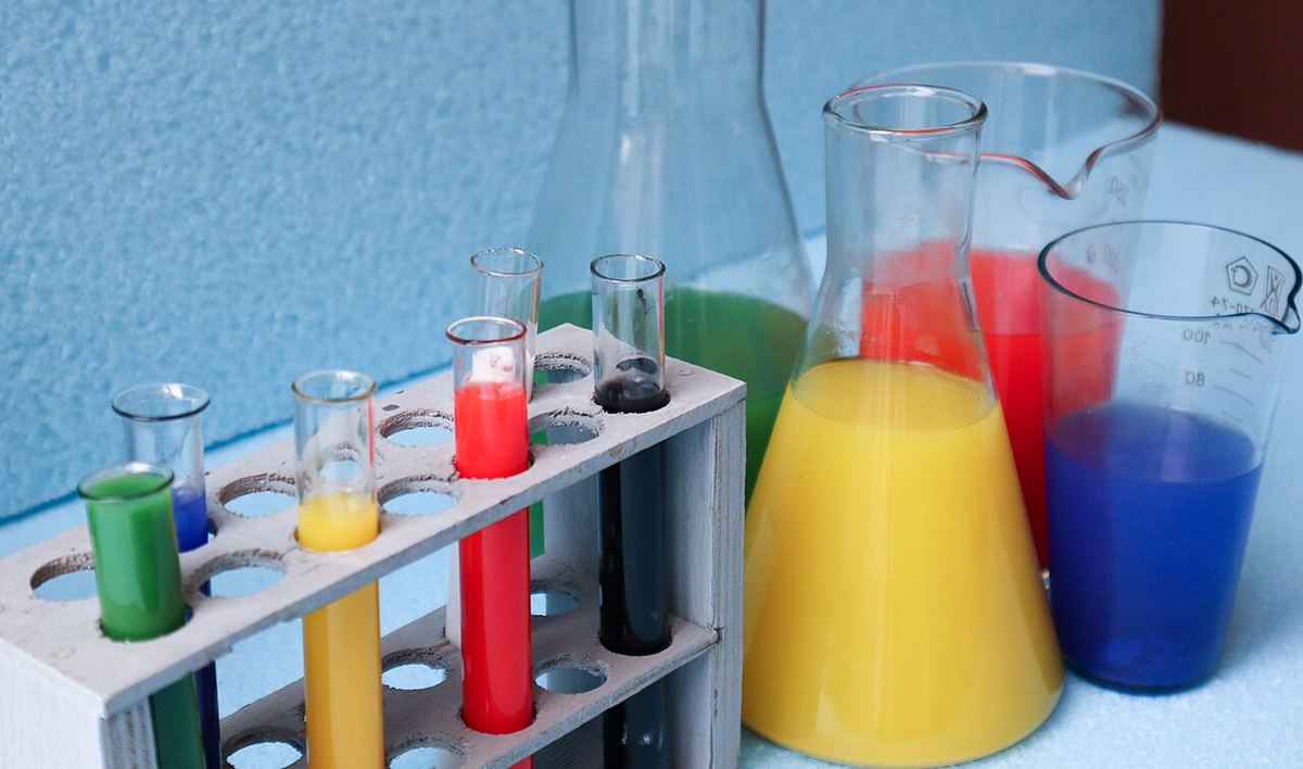 Test tubes and beakers filled with colorful liquids on a laboratory bench